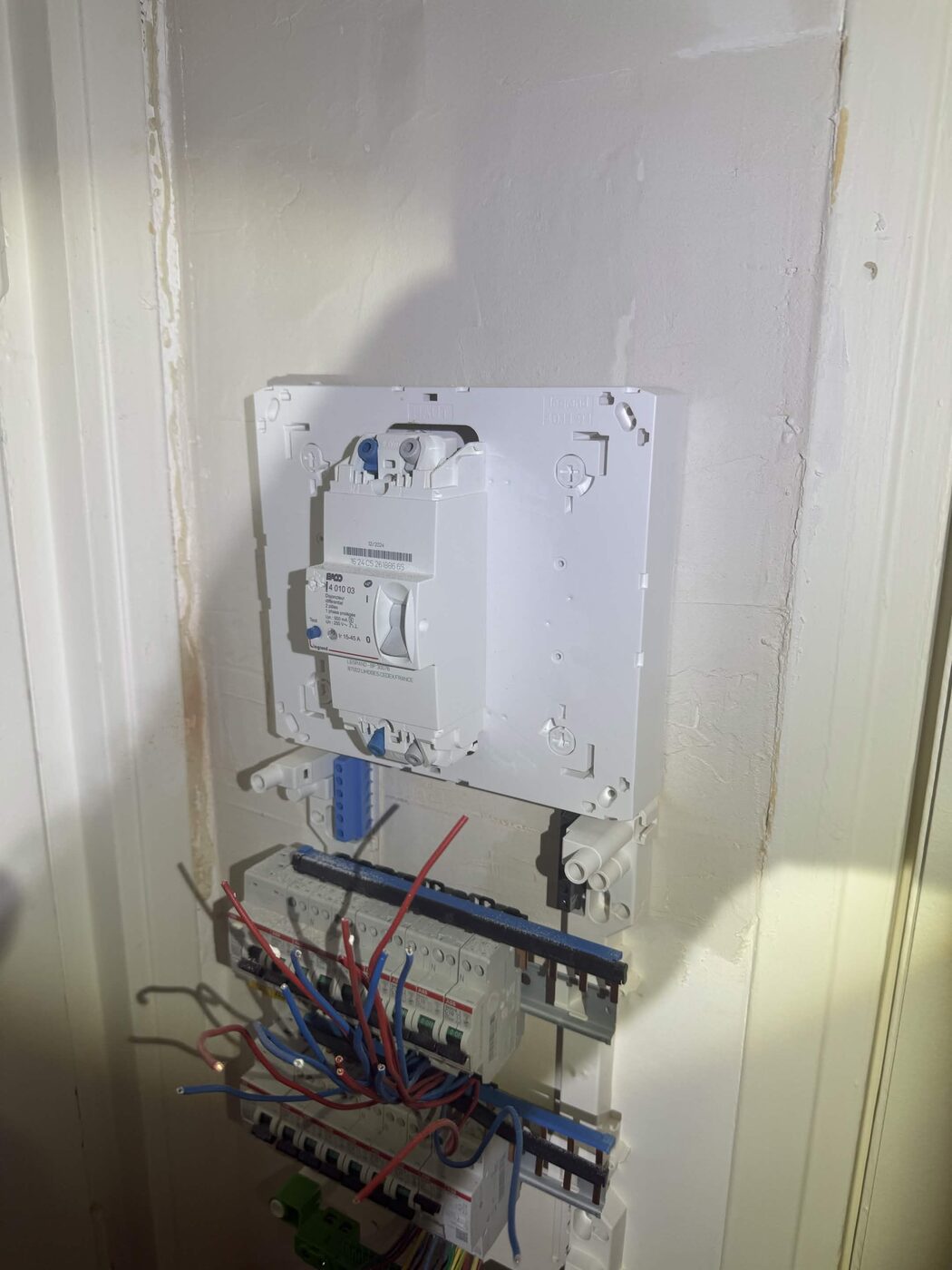 Module du disjoncteur d'abonné fixé au mur, câbles raccordés en attente du reste de l'installation