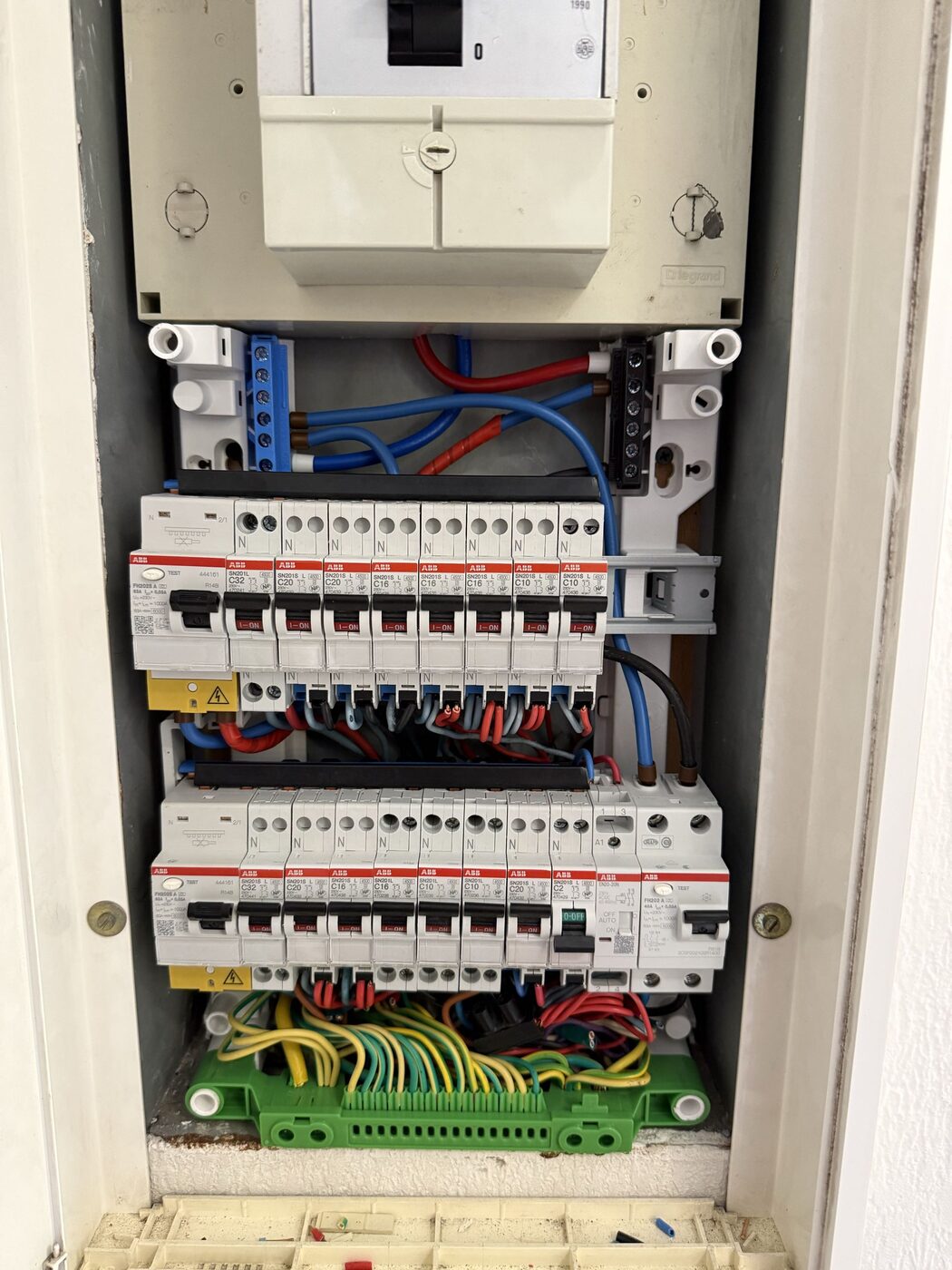 Nouveau tableau électrique avec disjoncteurs ABB fraîchement installés, câblage en cours avant repérage des circuits